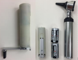 Crank-powered otoscope battery replacement, next to two C-cell batteries