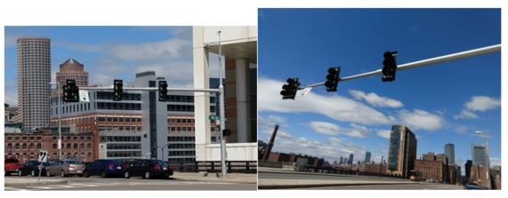 Two photographs of traffic signals in Boston: three signal heads hanging from a horizontal mast arm over an intersection with the city skyline behind, and a view looking up along the mast arm against a blue sky