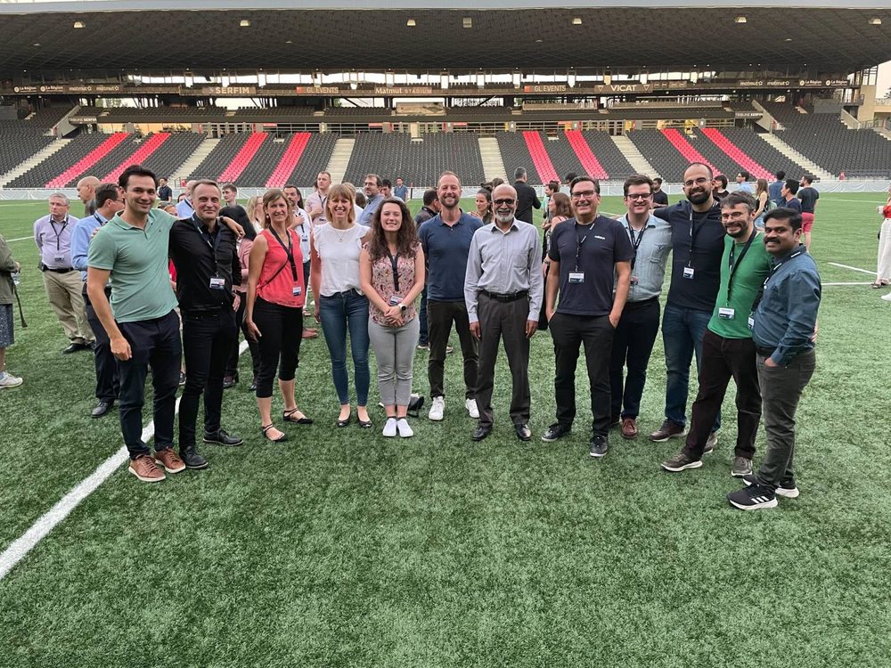 A large group standing on the pitch of a stadium during a conference evening event